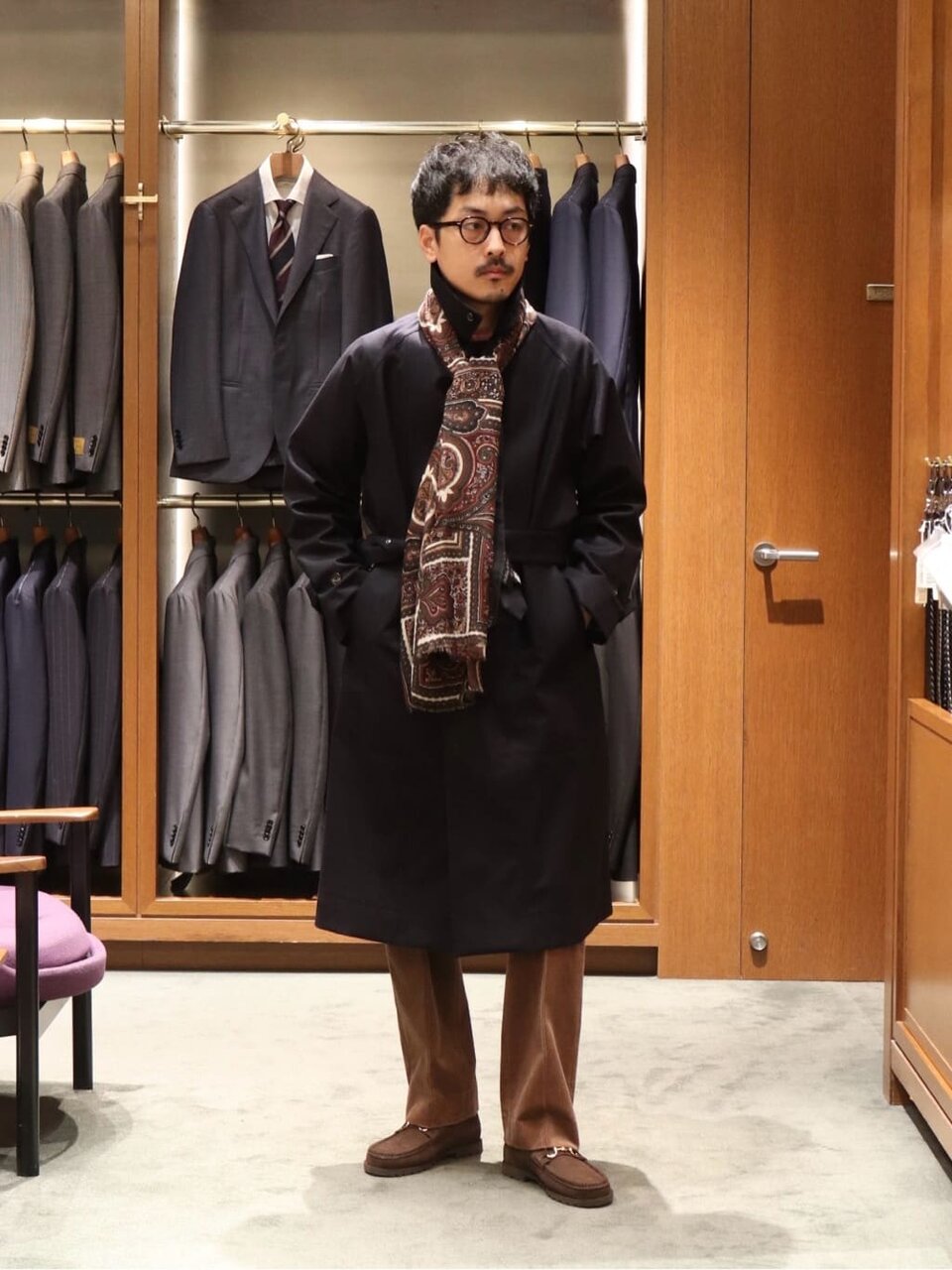 トレンチコートとコーデュロイパンツを着た男性