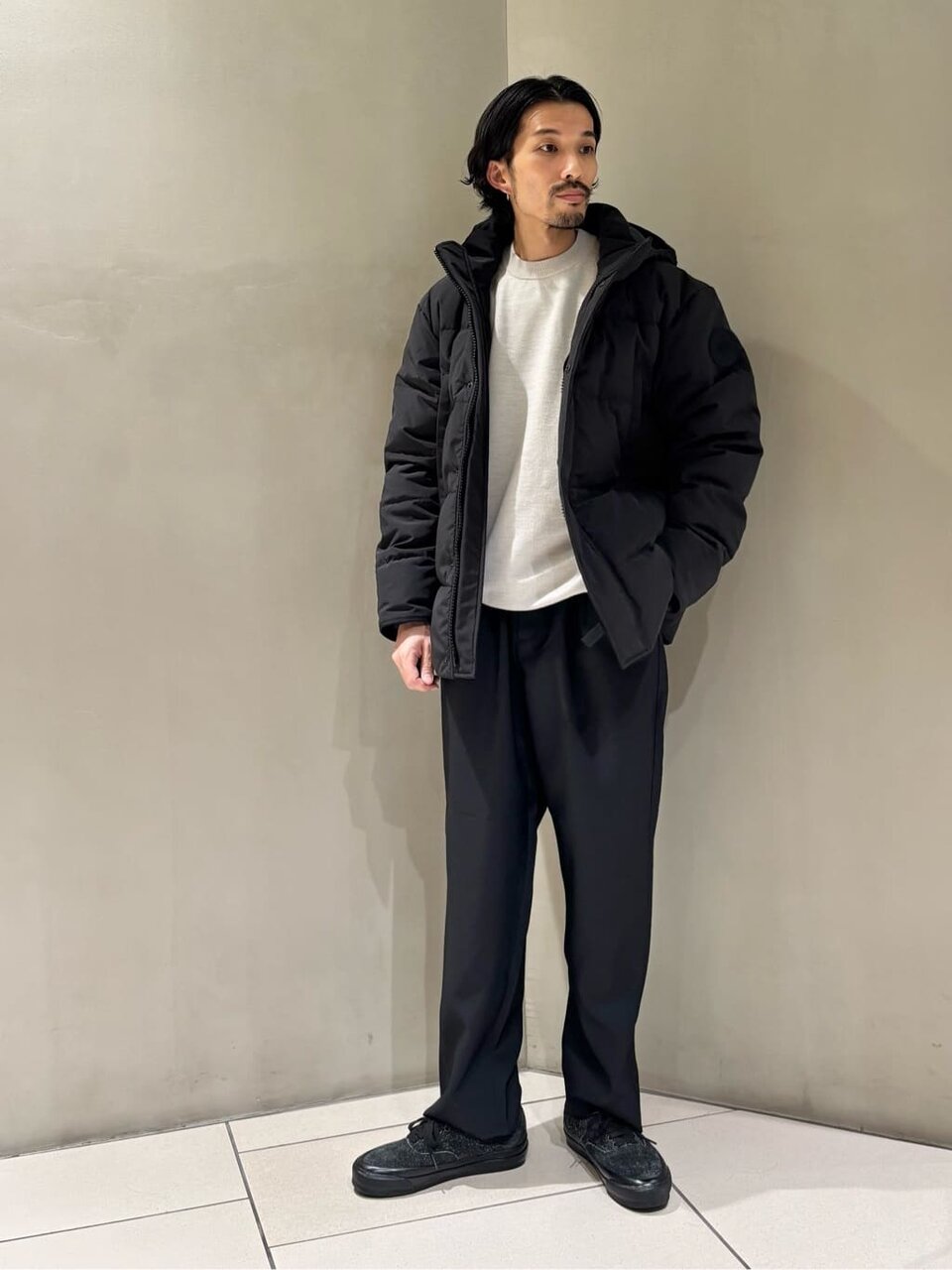 ダウンジャケットとスラックスを着た男性