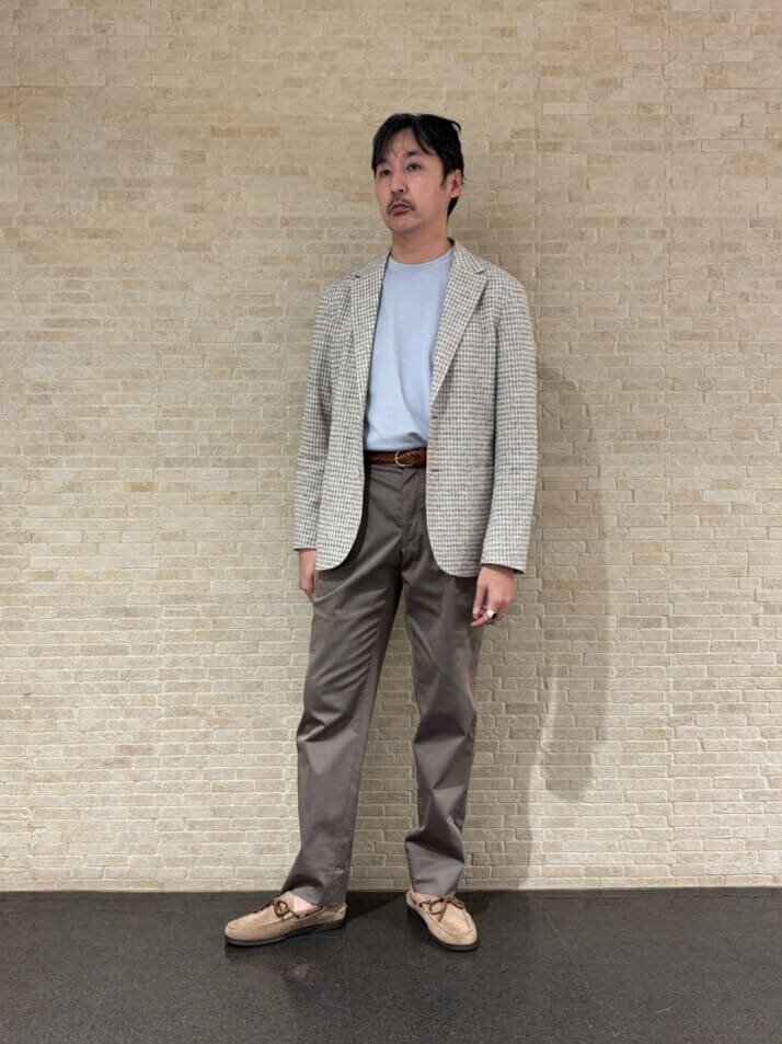 チェックテーラードジャケットとチノパンを着た男性