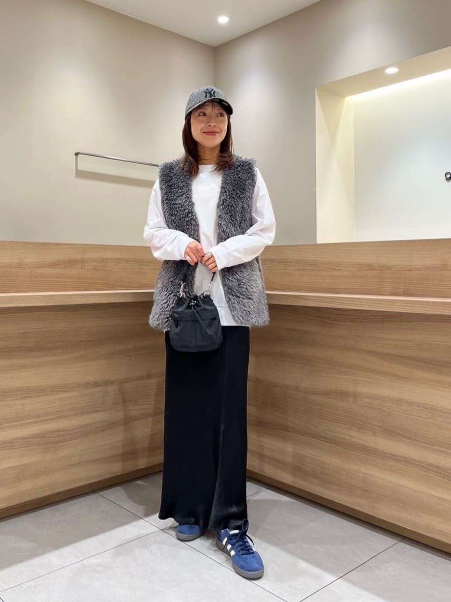 ボアジレとサテンスカートを着た女性