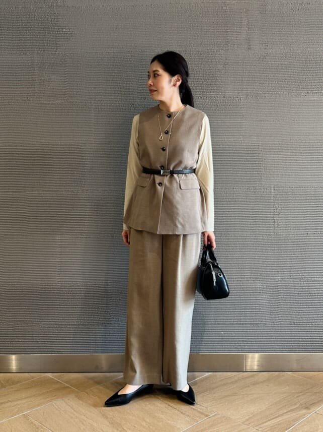 ノーカラージレとワイドパンツを着た女性