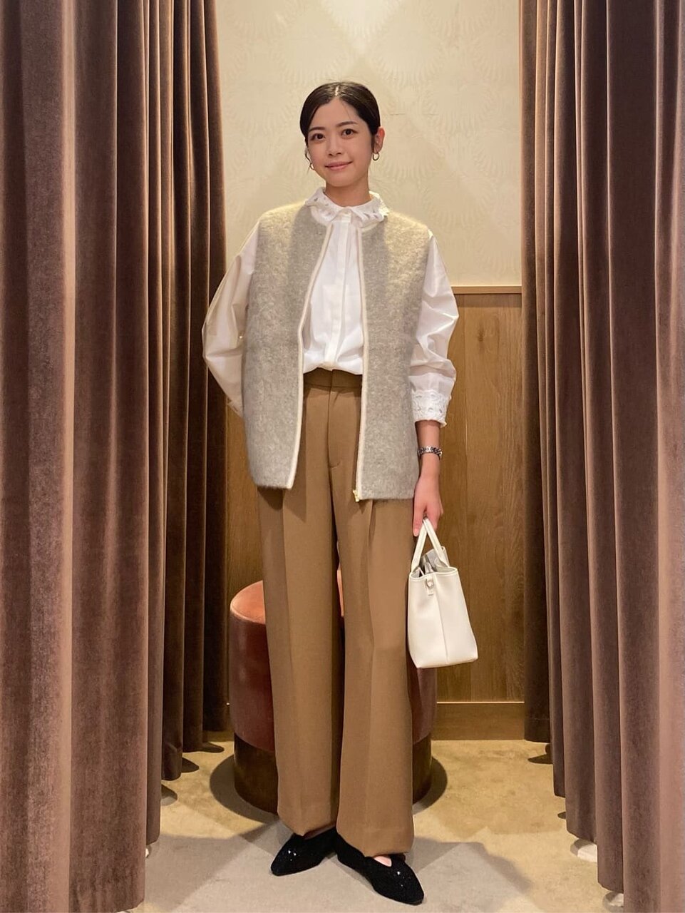 フリルブラウスとジレを着た女性