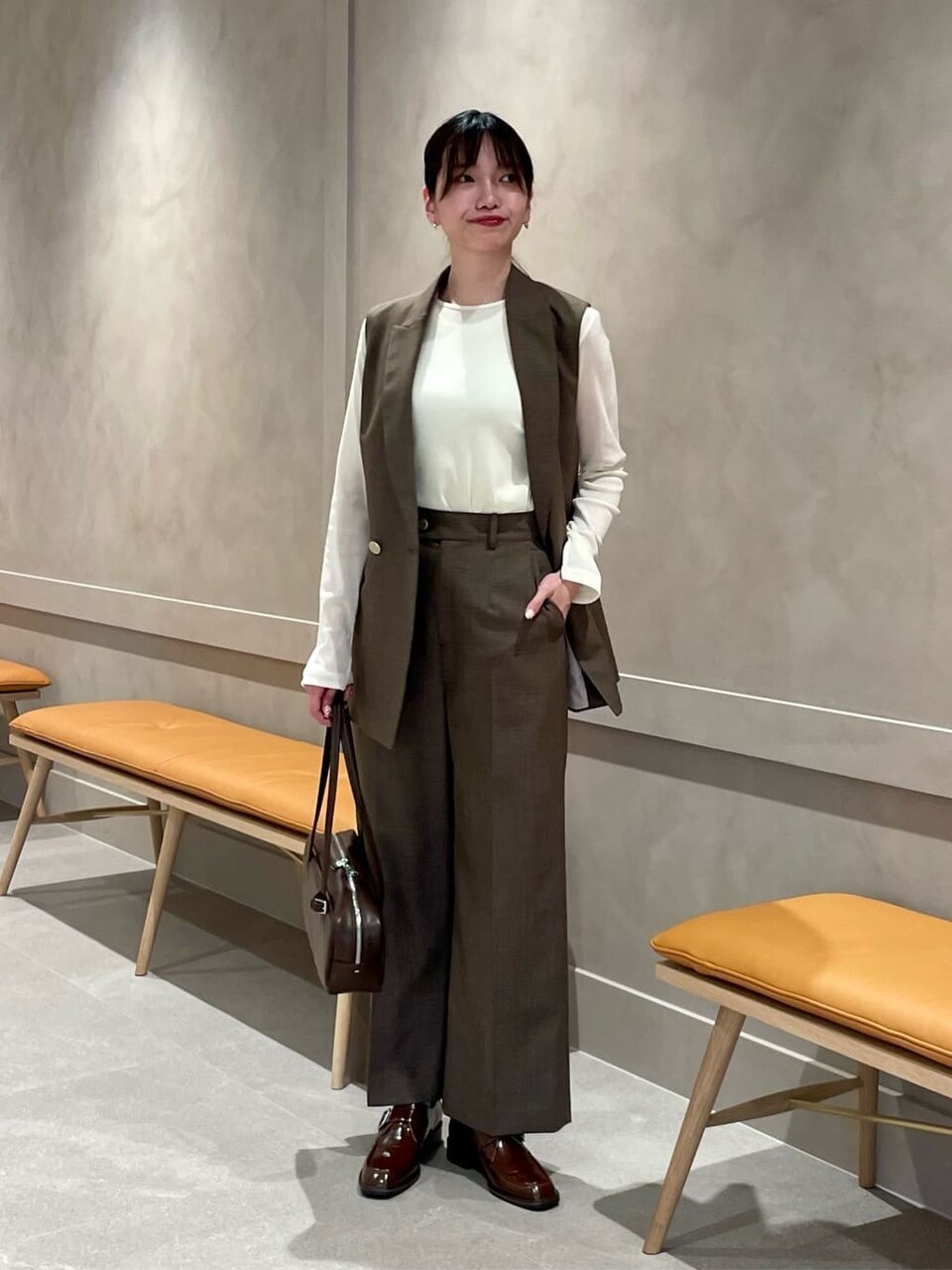 テーラードジレとワイドパンツを着た女性