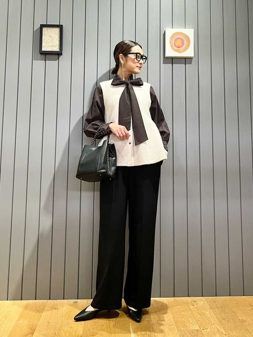 リボンたいブラウスとジレを着た女性