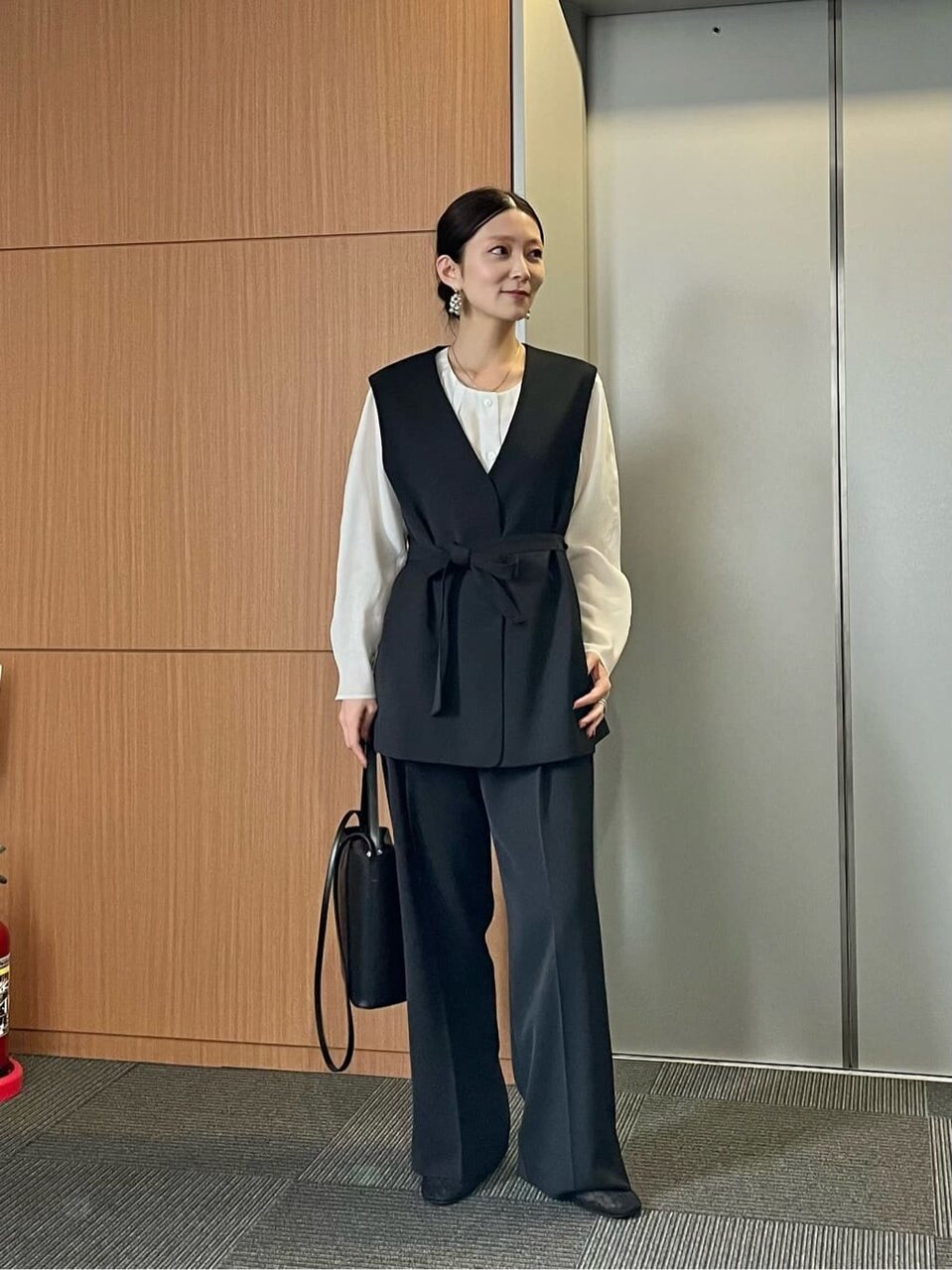 ジレと白いブラウスを着た女性