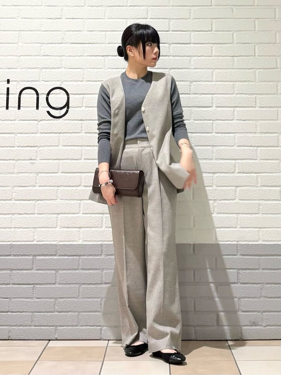 ノーカラージレとワイドパンツを着た女性