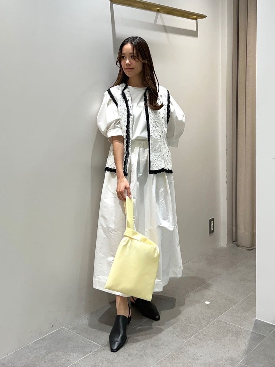 レースジレとフレアスカートを着た女性