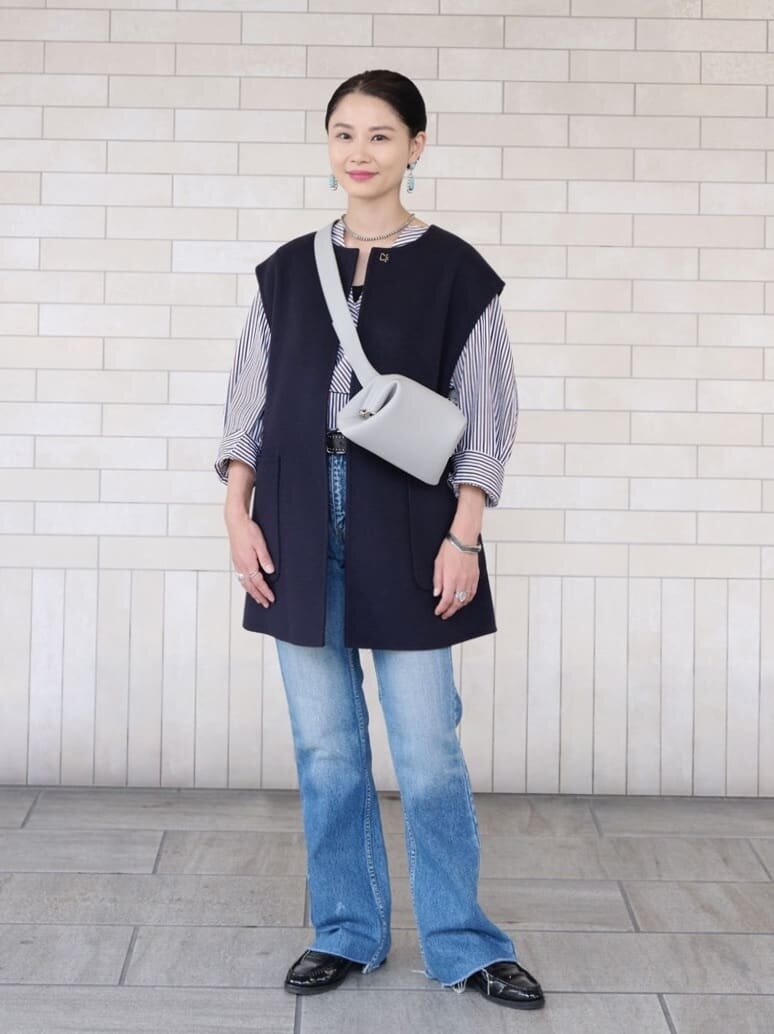 ロングジレとデニムを着た女性