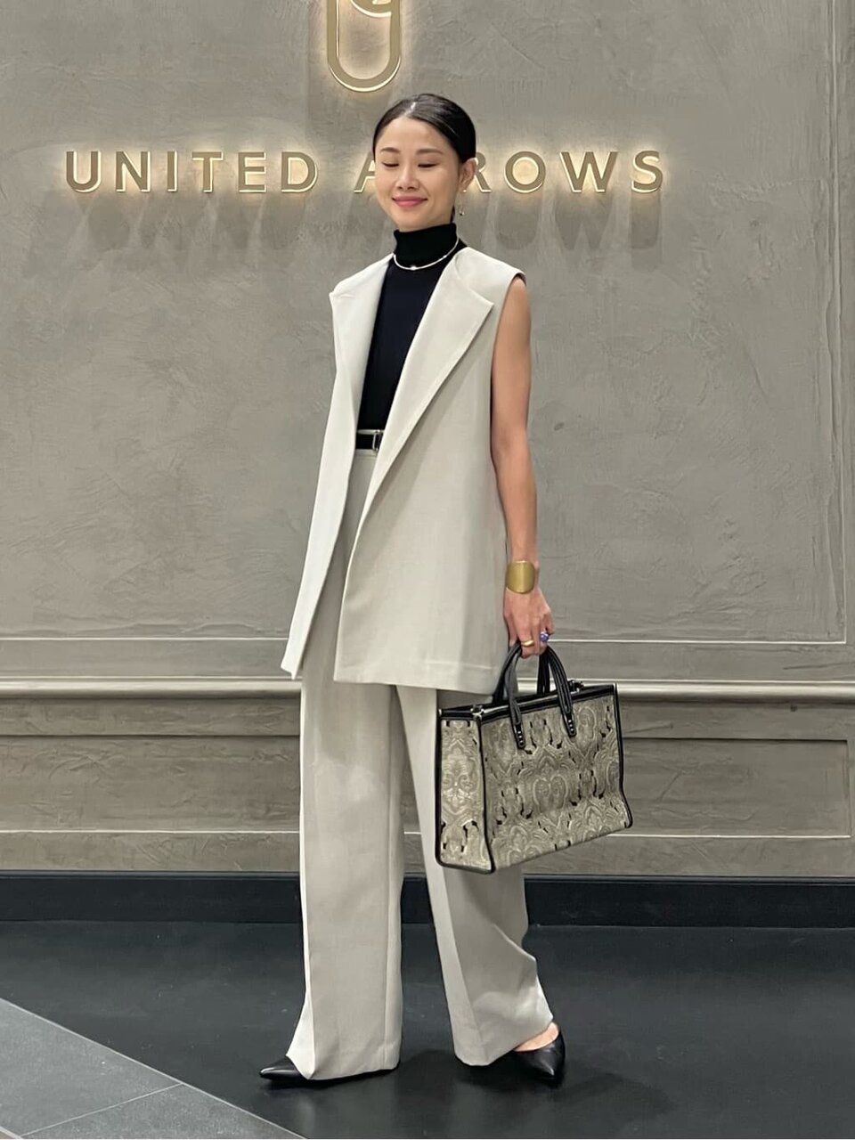 ノーカラージレとワイドパンツを着た女性