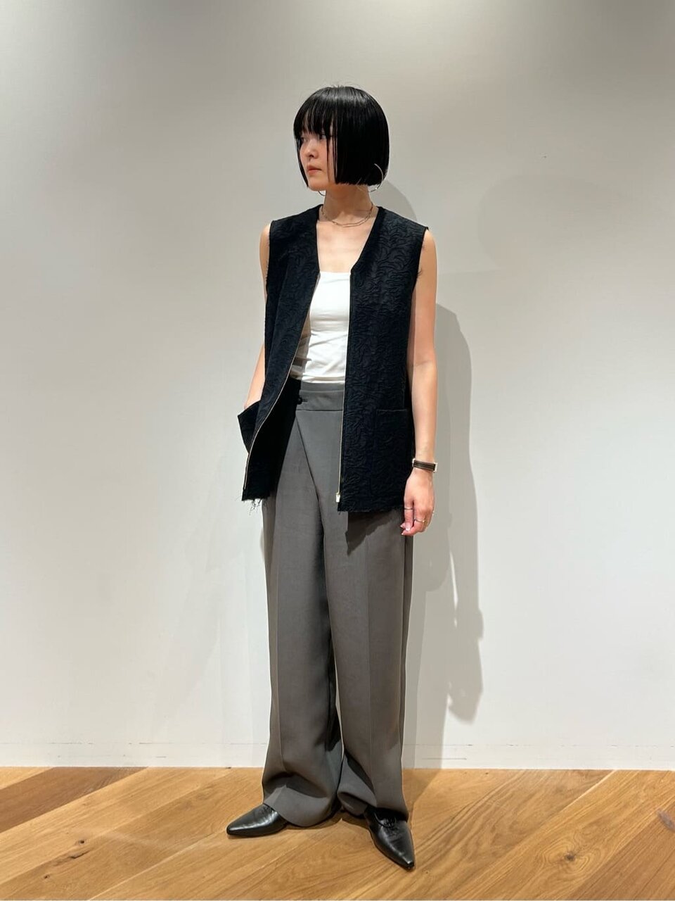 ジャガードジレとスラックスを着た女性