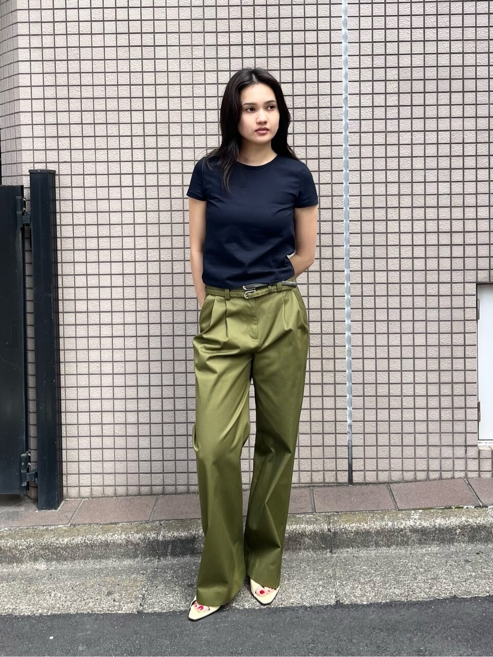 ネイビーのTシャツとカーキのパンツを着た女性