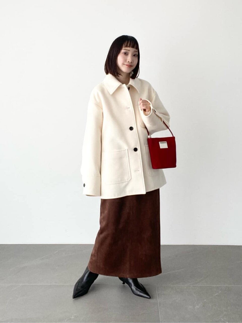 白いコートと茶色いスカートを着た女性