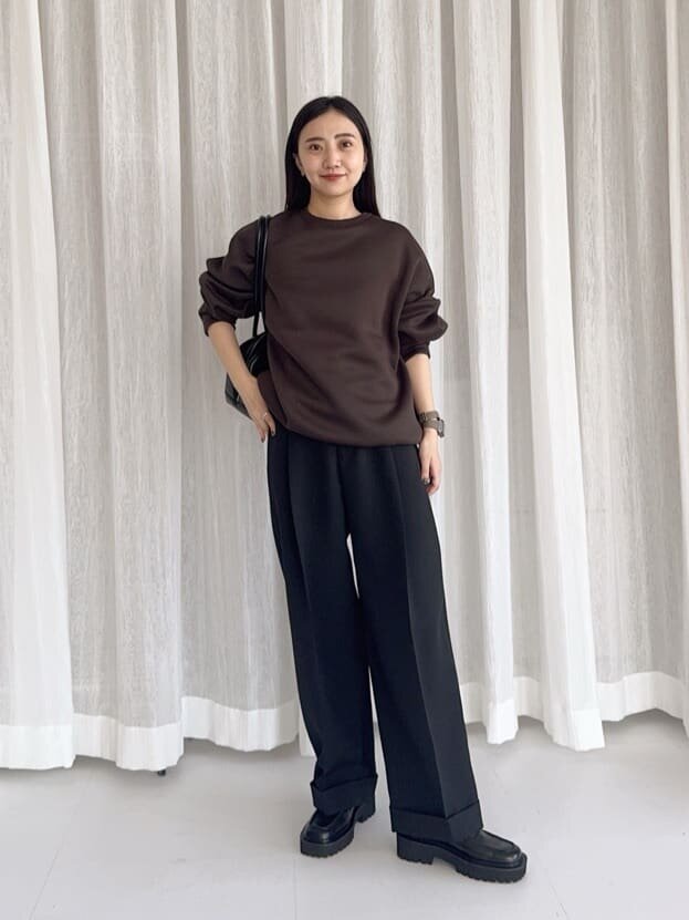 茶色のスウェットと黒のパンツを着た女性