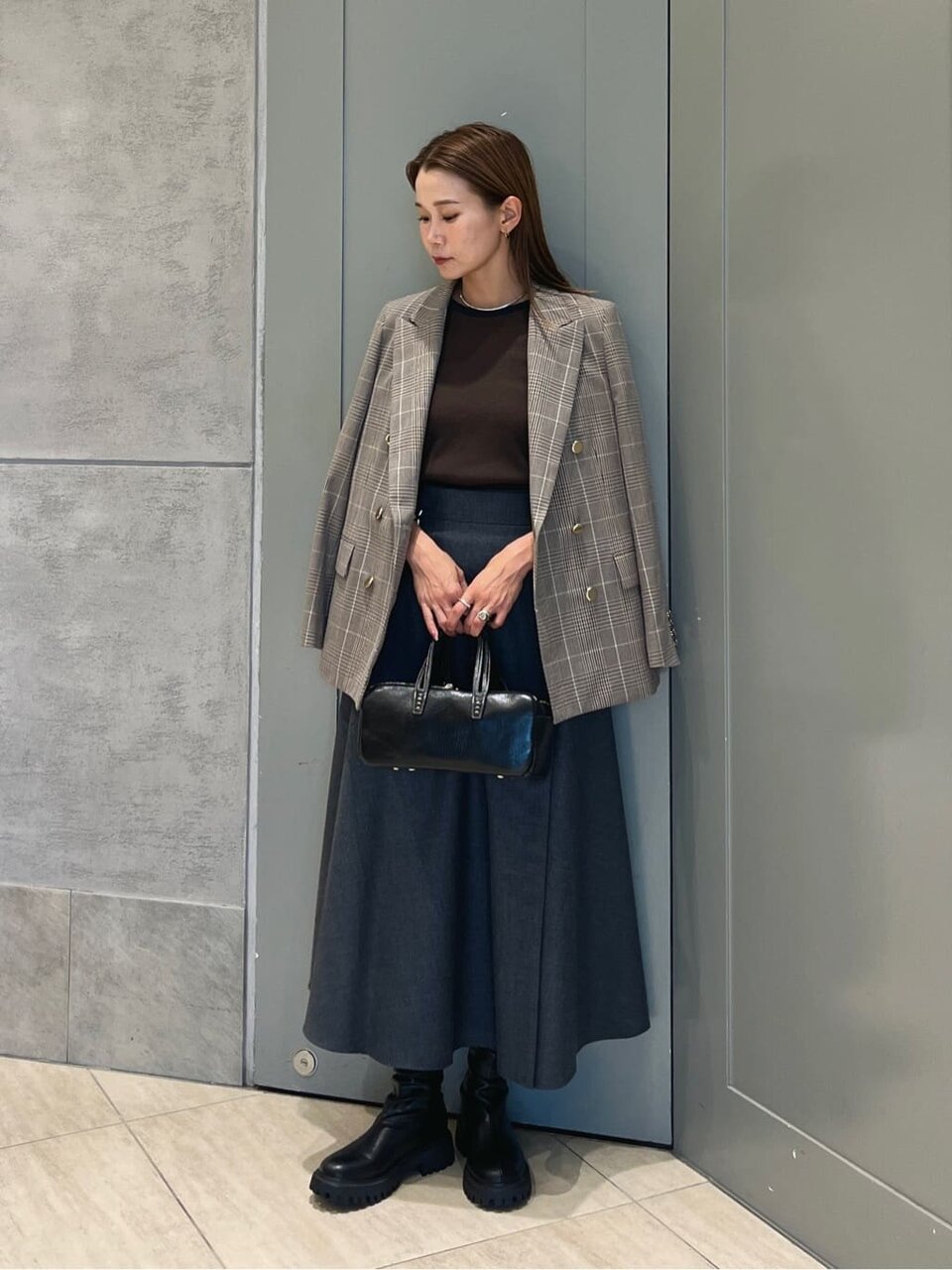 チェックジャケットとグレーのスカートを着た女性