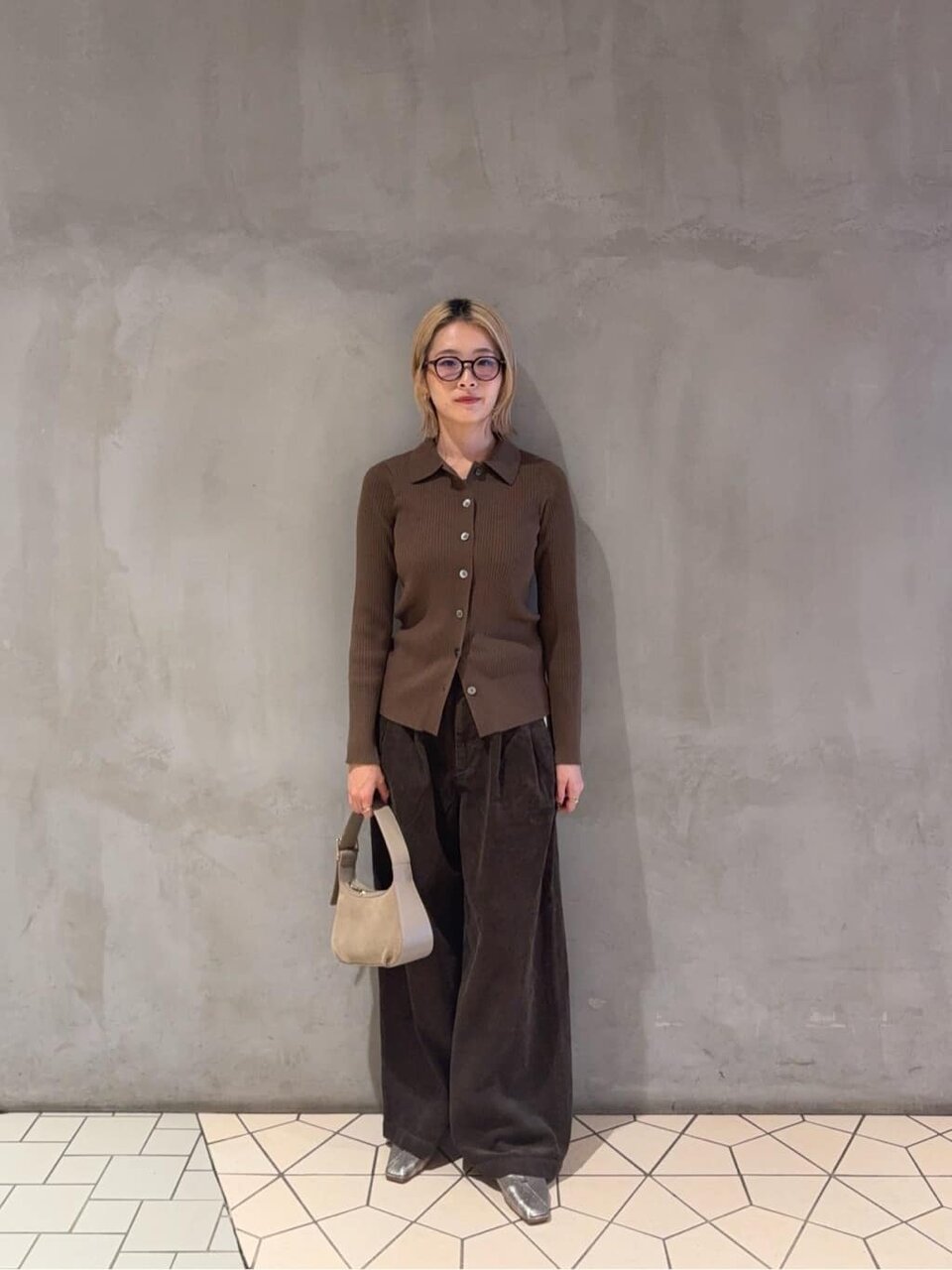 ブラウンのリブニットとパンツを着た女性