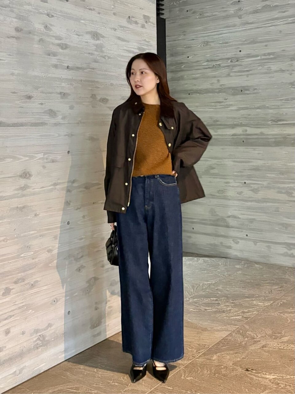 ブラウンのジャケットとデニムを着た女性