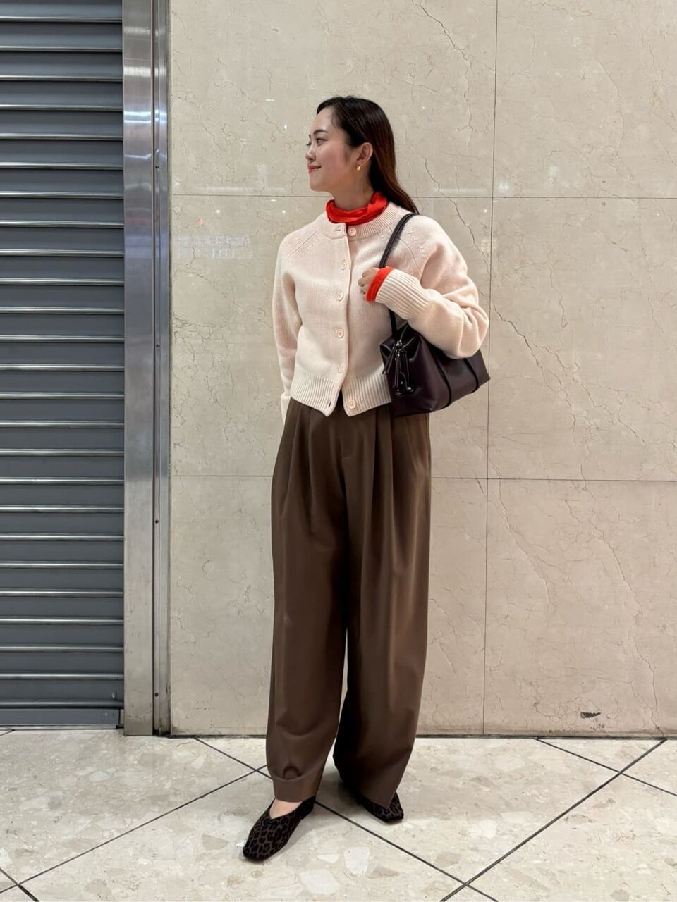 カーディガンと茶色いお案つを着た女性