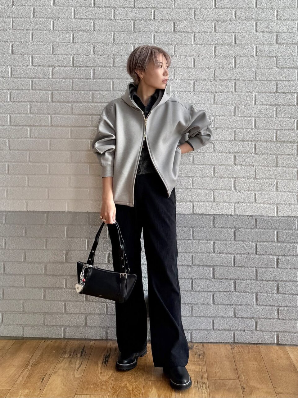 グレーのブルゾンとパンツを着た女性