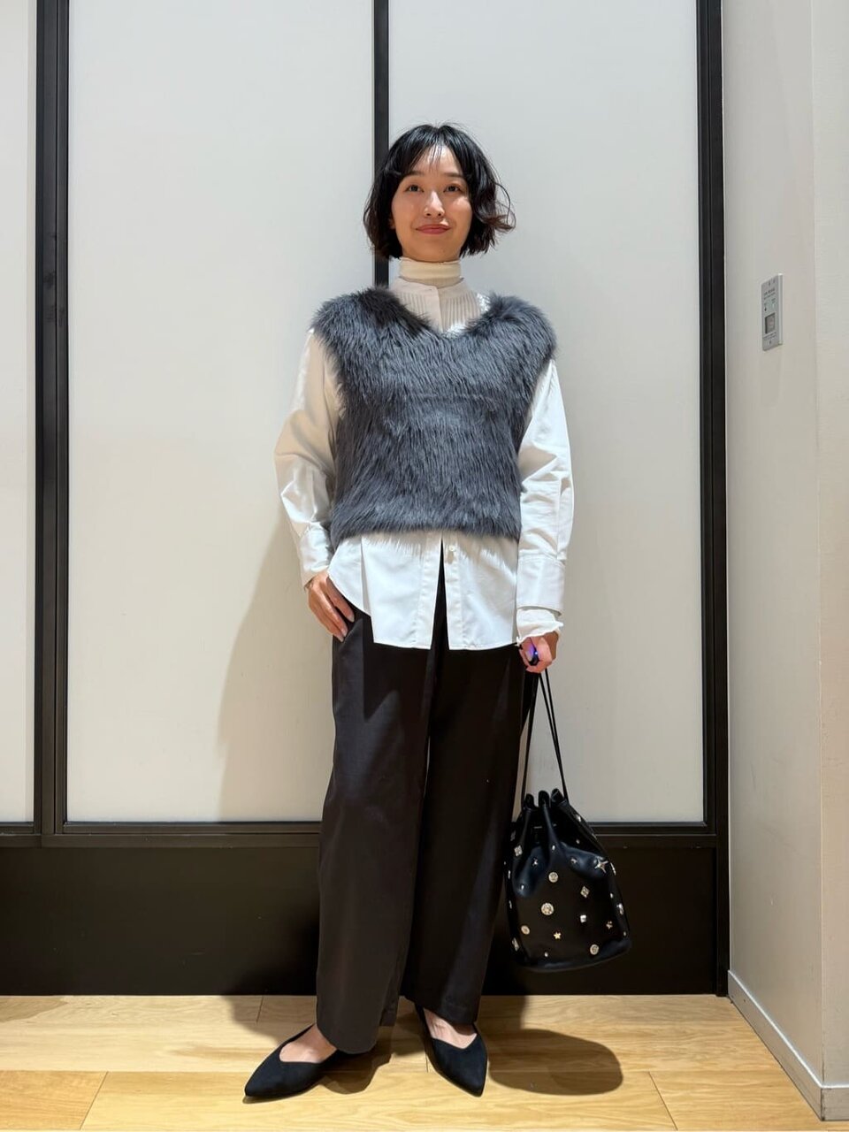 グレーのベストと白いシャツを着た女性