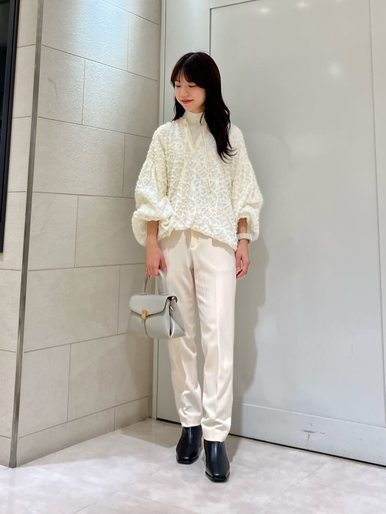 ブラウスとテーパードパンツを着た女性