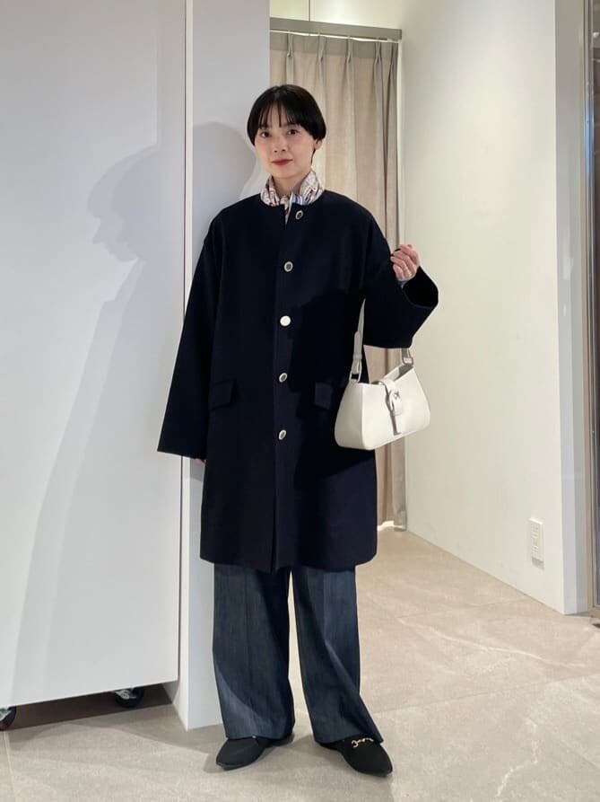 ノーカラーコートを着た女性