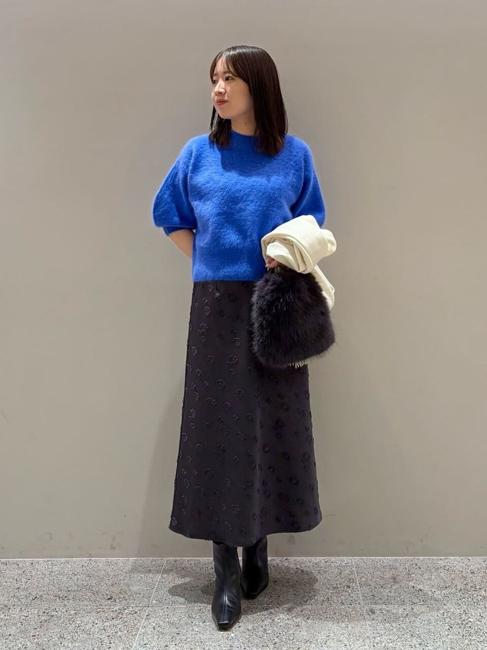 ブルーのニットにジャガースカート、ストールをあわせたコーデ