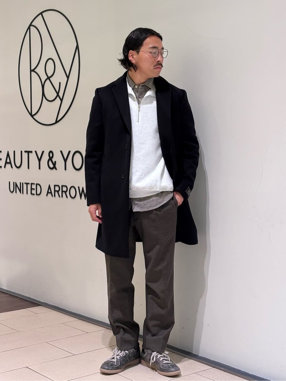 黒のチェスターコートを着た男性