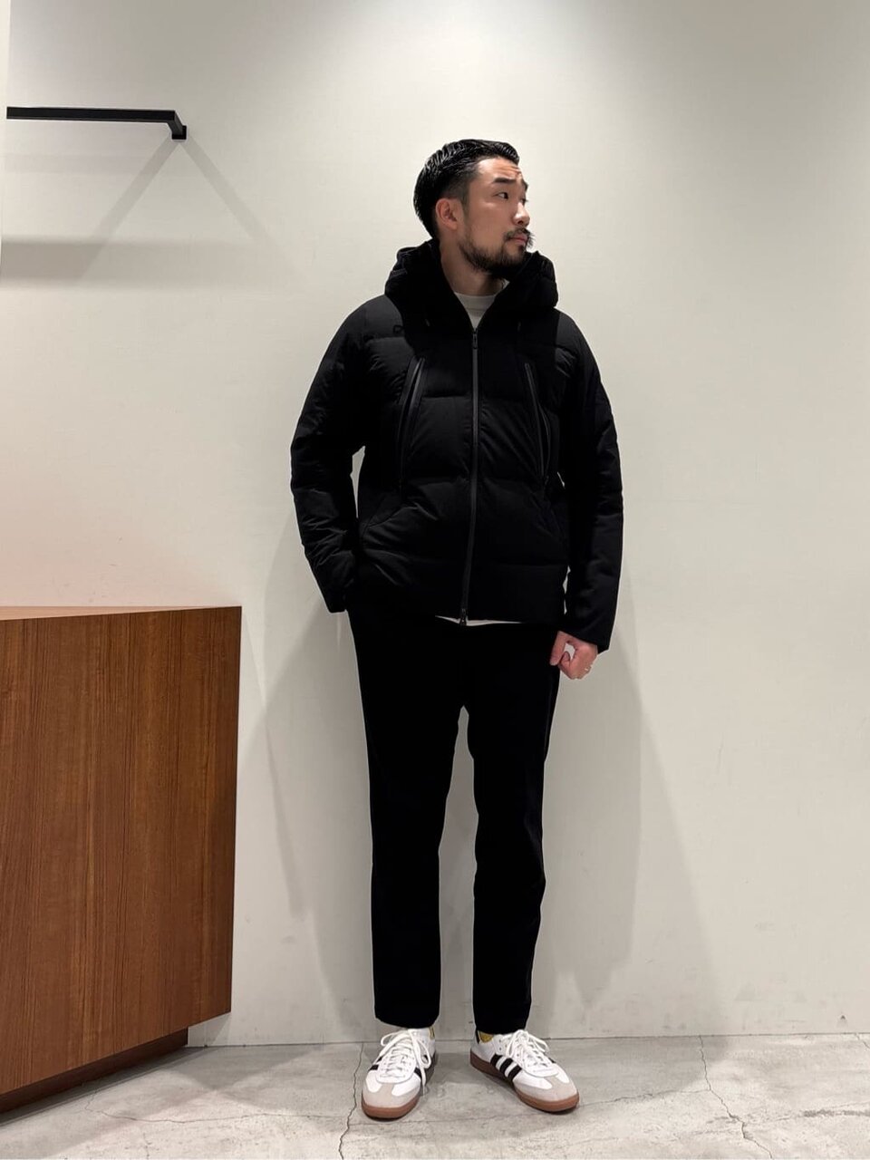 ダウンジャケットにスニーカーをあわせた男性