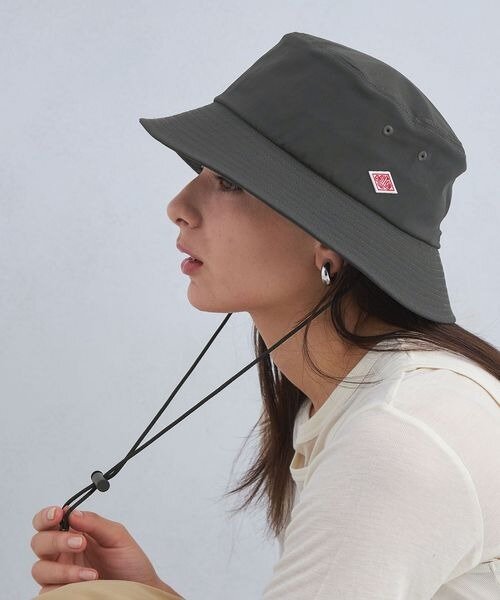 紐付きのバケットハットをかぶった女性