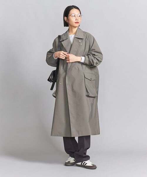 トレンチコートをラフに着た女性