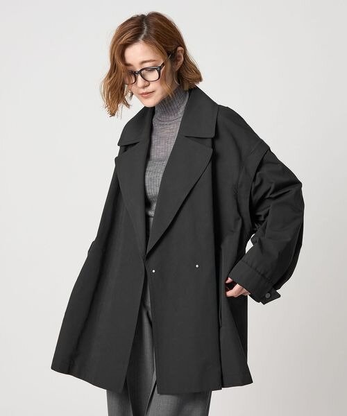 ニットにトレンチコートをあわせた女性