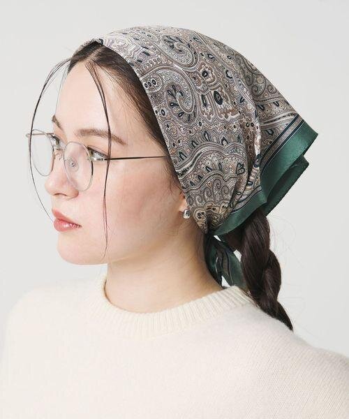 スカーフを頭に巻いてアレンジしている女性