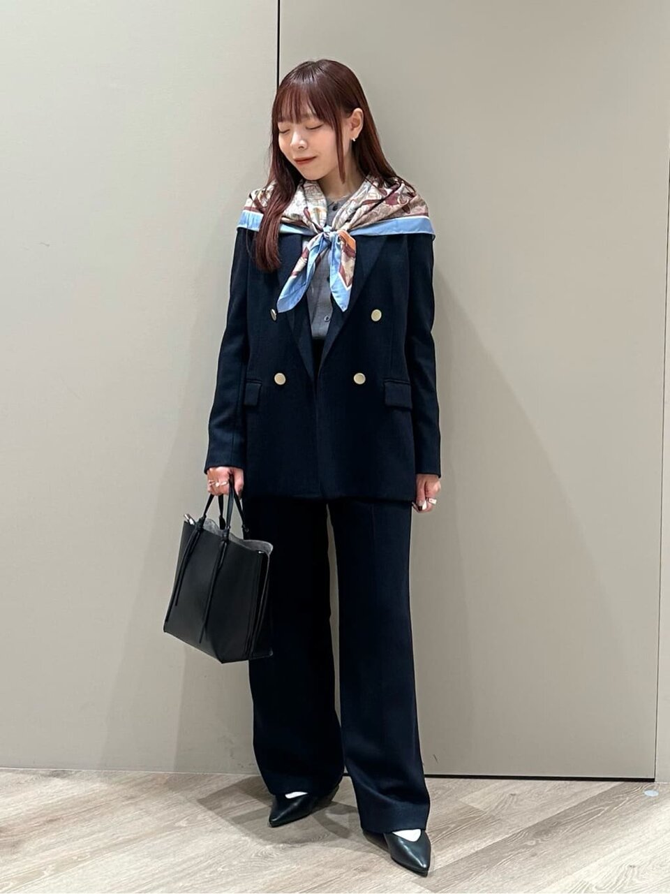 ジャケットにスカーフをあわせた女性