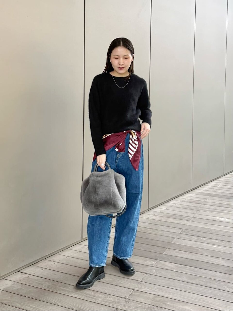 デニムパンツにスカーフをあわせた女性