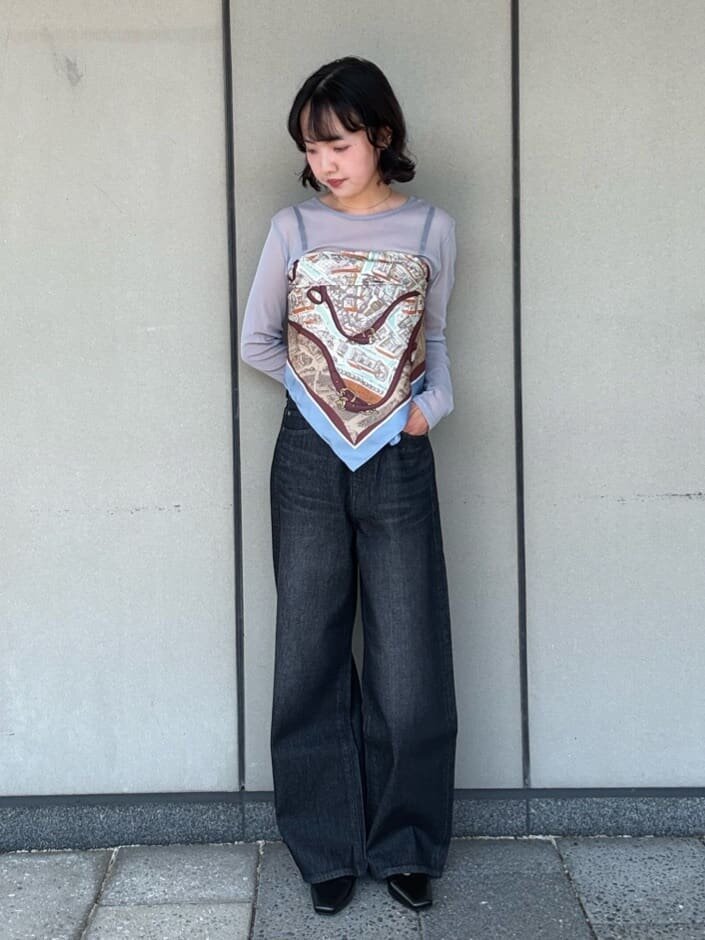 スカーフをシアートップスの上に巻いた女性