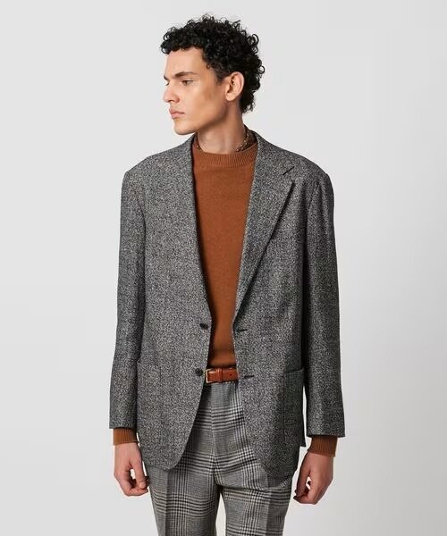 黒のツイードジャケットを着ている男性