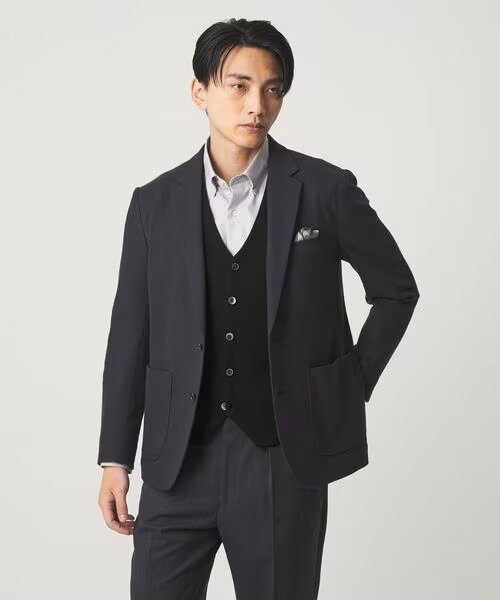 黒のニットベストを着ている男性