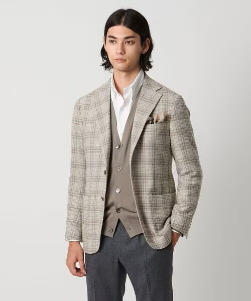 ベージュのカーディガンをインナーにしている男性