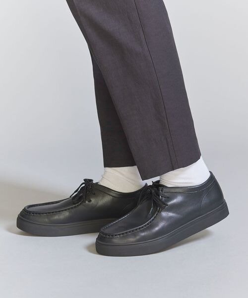 ブラックのモックスニーカーを履く男性