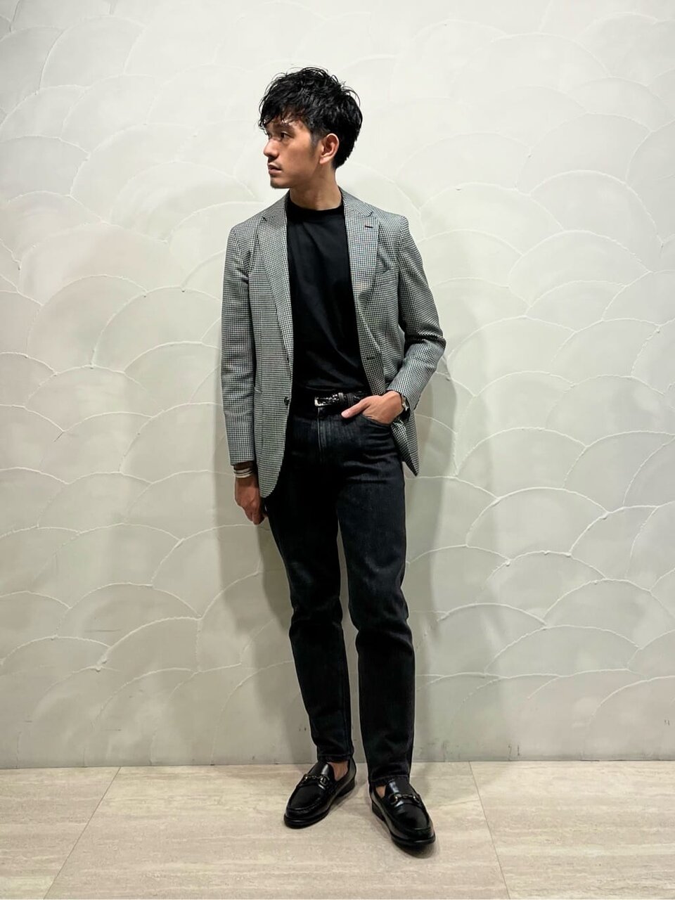 ジャケットとデニムパンツを着た男性
