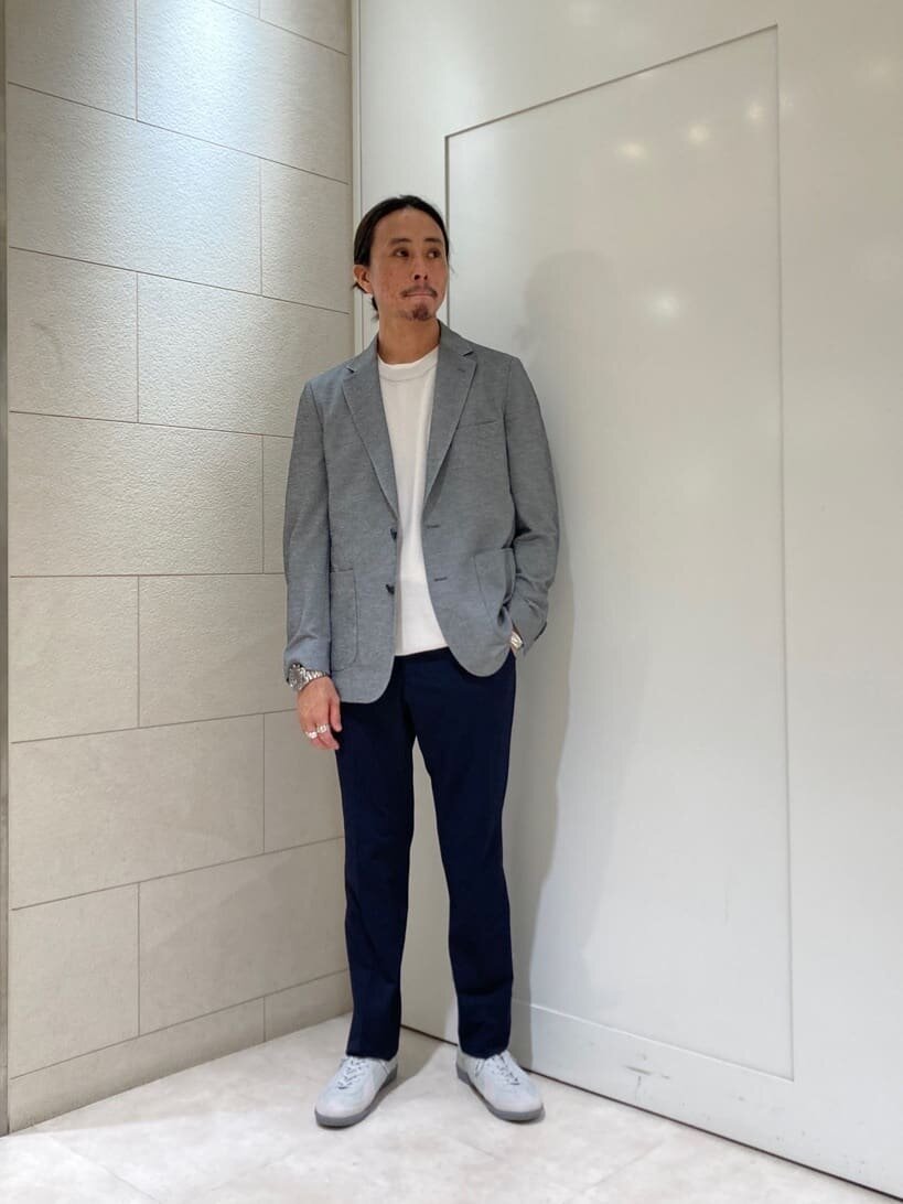 テーラードジャケットとニットを着た男性