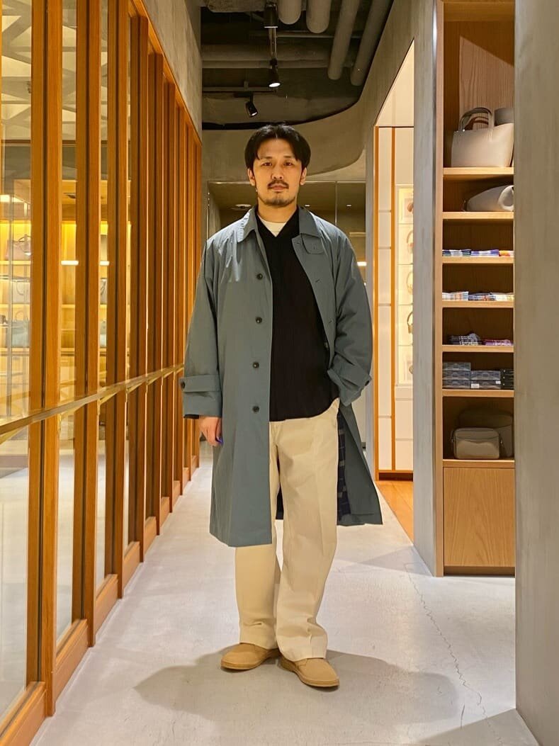 ステンカラーコートとミリタリーパンツを着た男性