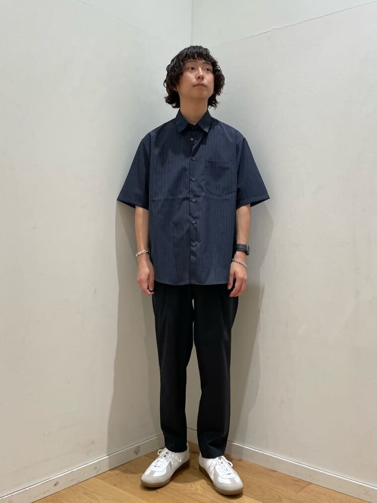 ストライプ柄シャツとイージーパンツを着た男性