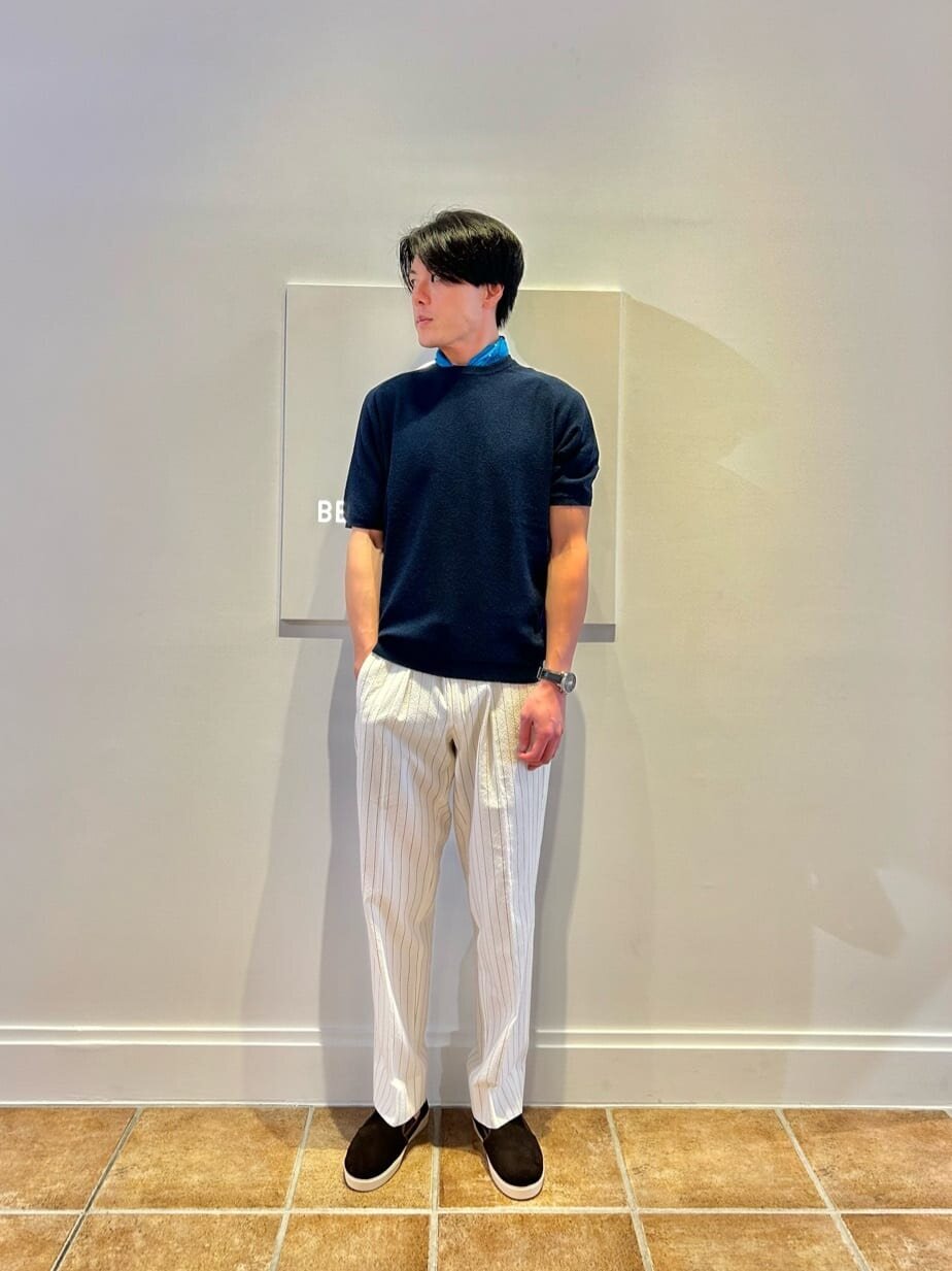 ニットとスラックスを着た男性