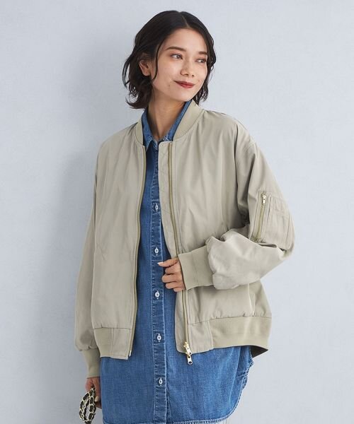 ライトグレーのMA-1を羽織った女性