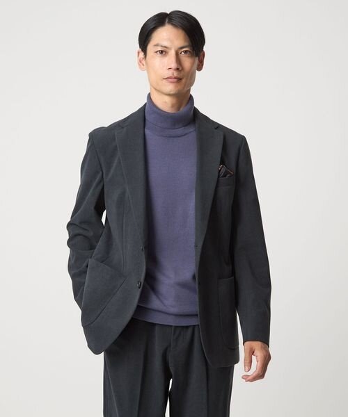 パープルのタートルネックをスーツに合わせた男性