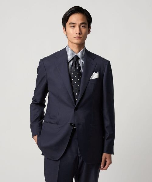 ネイビースーツにストライプシャツとドットタイを合わせた男性