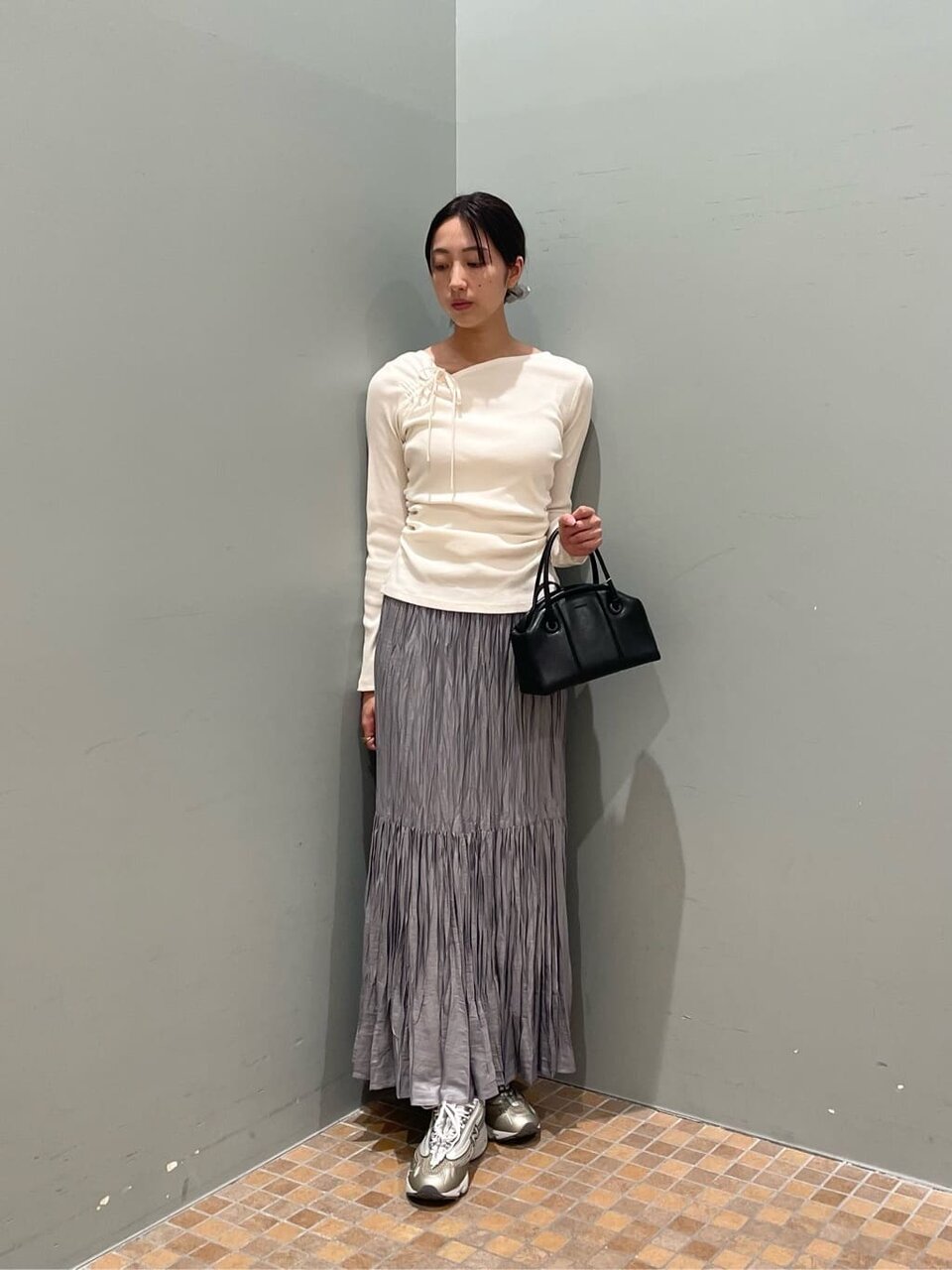 オフホワイトのカットソー×ライトグレーのプリーツスカートのコーデ