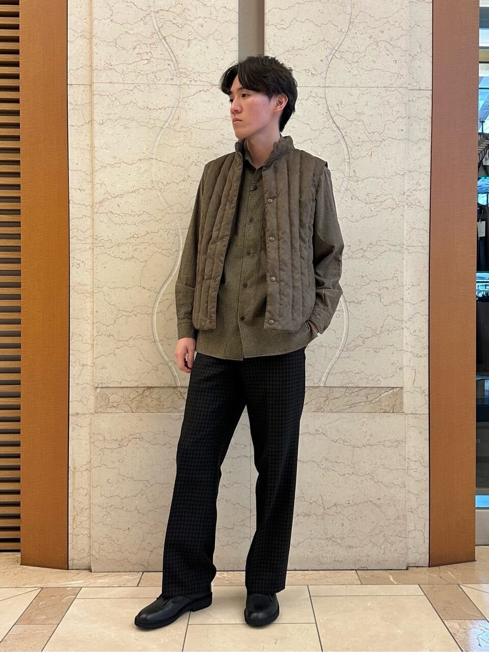 ブラウンのダウンベストを着た男性