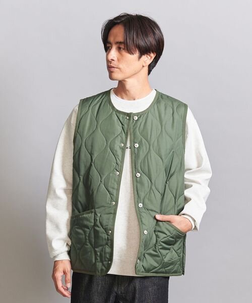 オリーブのダウンベストを着た男性